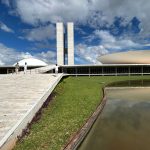 Vista do Congresso Nacional do Brasil sob um céu claro.