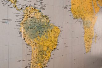 Close de um mapa antigo destacando a América do Sul e partes da África.