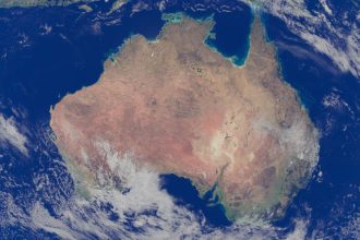 Imagem de satélite da Austrália cercada pelo Oceano Pacífico e por outras áreas oceânicas.
