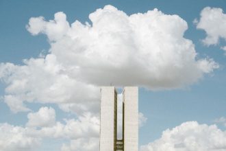 Vista do Congresso Nacional em Brasília, com as cúpulas e torres do edifício sob um céu nublado.