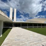 Vista externa do Congresso Nacional do Brasil sob um céu claro.