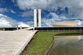 Vista externa do Congresso Nacional do Brasil, com suas cúpulas e torres sob céu claro.