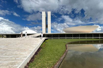 Vista externa do Congresso Nacional do Brasil, com suas cúpulas e torres sob céu claro.